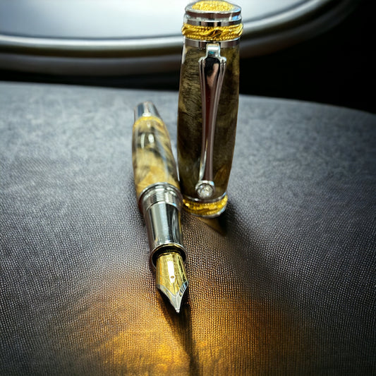 The Marseille a hand crafted fountain pen. Featuring 22 karat gold accents, faceted Swarovski crystal in the clip, and hand crafted from buckeye burl wood. 